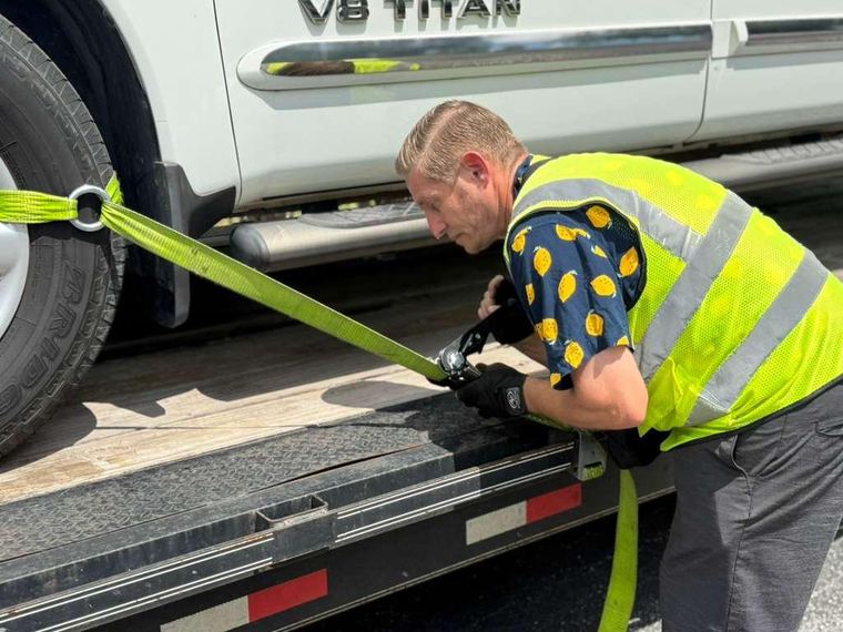 Shoppiis operator ratcheting a wheel strap during loading